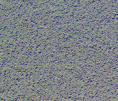 Il s'agit d'une microphotographie des piqûres sur le bord intérieur d'un CD-ROM ; exposition de 2 secondes sous lumière fluorescente visible.