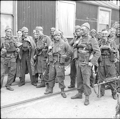 Un groupe de 15 hommes en uniforme portant des armes