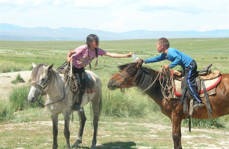 Une fille et un garçon à cheval