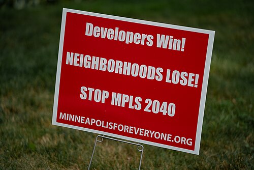 Un panneau sur la pelouse indique : « Les promoteurs gagnent, les quartiers perdent ! Arrêtez MPLS 2040 »