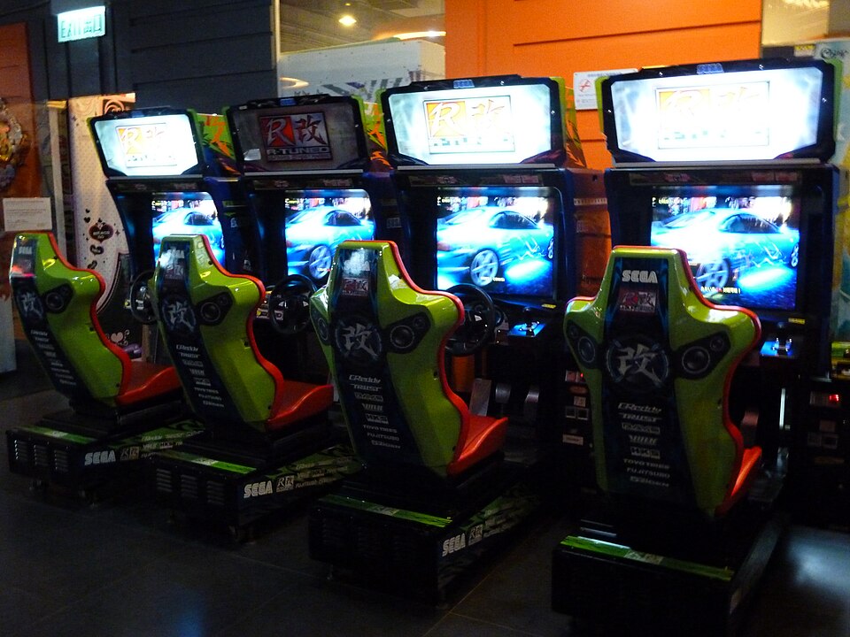 Quatre bornes d'arcade avec sièges et volants en rangée, de couleur verte