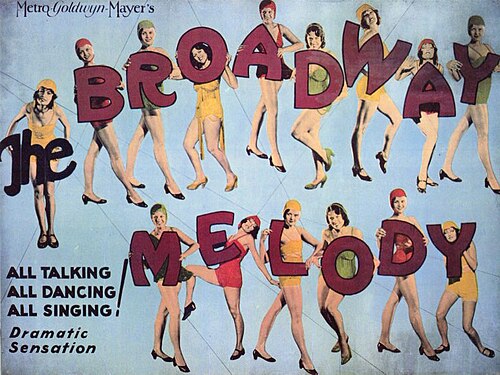 Affiche de film représentant quinze jeunes femmes en tenue de danse. La première porte le mot « The » en grandes lettres. Les quatorze autres portent les lettres individuelles qui composent « Broadway Melody ». Le texte qui l'accompagne dit : « Tout le monde parle, tout le monde danse, tout le monde chante ! Sensation dramatique. »