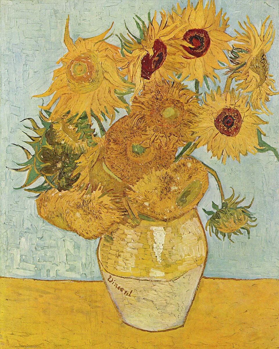 Un vase en céramique orné de tournesols sur une surface jaune se détachant sur un fond bleu pâle.