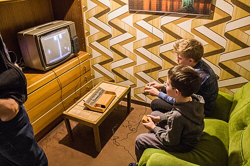Deux enfants jouent au Pong sur un téléviseur.