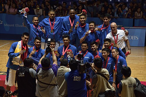 Photo d'équipe, avec chaque membre en uniforme bleu portant une médaille d'or