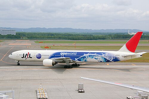 Un Boeing 777-300 de Japan Airlines peint dans une livrée spéciale Oneworld, circulant à l'aéroport de New Chitose