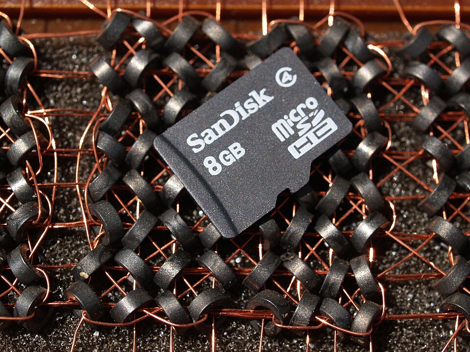 Cette carte microSDHC contient 8 milliards d'octets (8 Go). Elle repose sur une section de mémoire à tores magnétiques qui utilise 64 tores pour stocker huit octets. La carte microSDHC offre donc une capacité plus d'un milliard de fois supérieure dans un espace physique bien plus réduit.