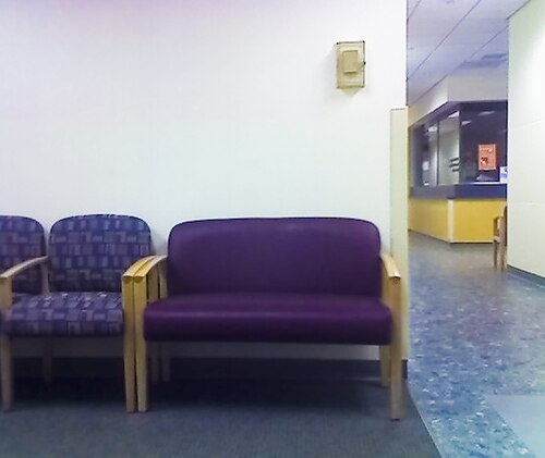 Une chaise extra large à côté d'un certain nombre de chaises de taille normale.