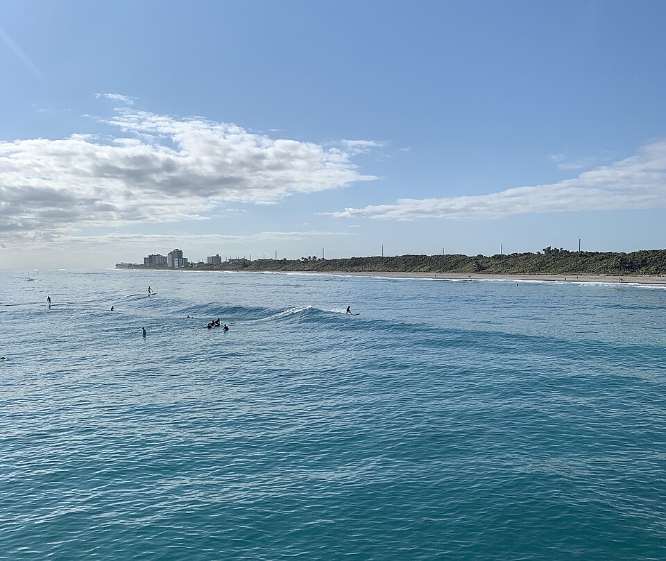 Un groupe de surfeurs surfant sur une vague de plage à Juno Beach, en Floride.