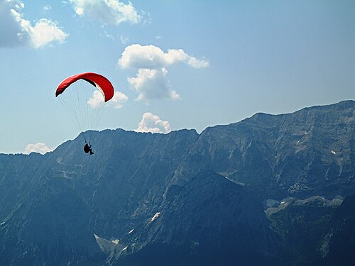 Notez l'aile du cerf-volant et les nombreuses lignes de cerf-volant tenues par l'opérateur humain ; l'opérateur se déplace par gravité (système de cerf-volant parapente)