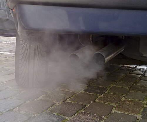 gros plan de 2 tuyaux d'échappement avec de la fumée blanchâtre