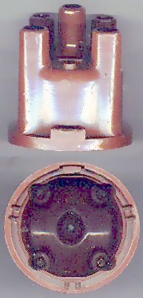 Bouchon de distributeur. Au centre se trouve un bouton en carbone à ressort qui touche le rotor. Le nombre de contacts (dans ce cas 4) est le même que le nombre de cylindres du moteur.