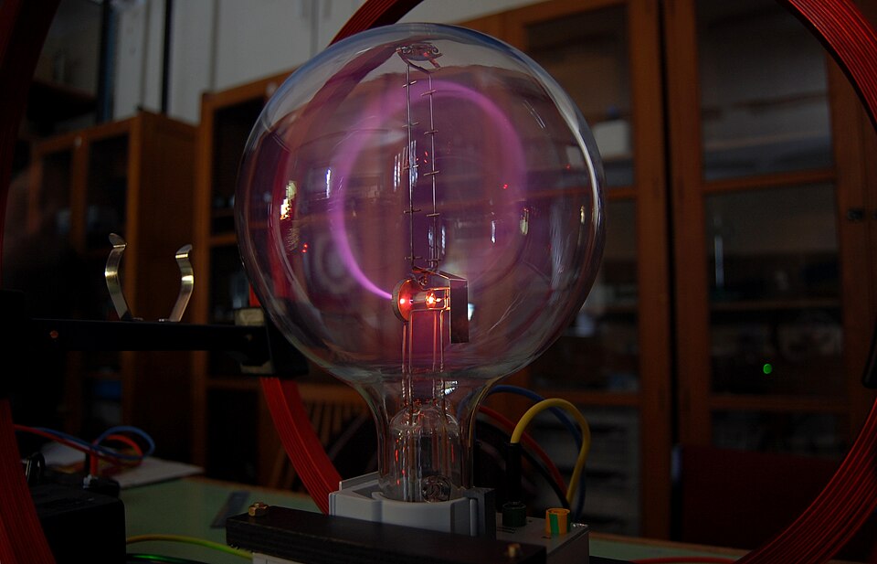 Un tube à vide en verre rond avec un faisceau circulaire lumineux à l'intérieur