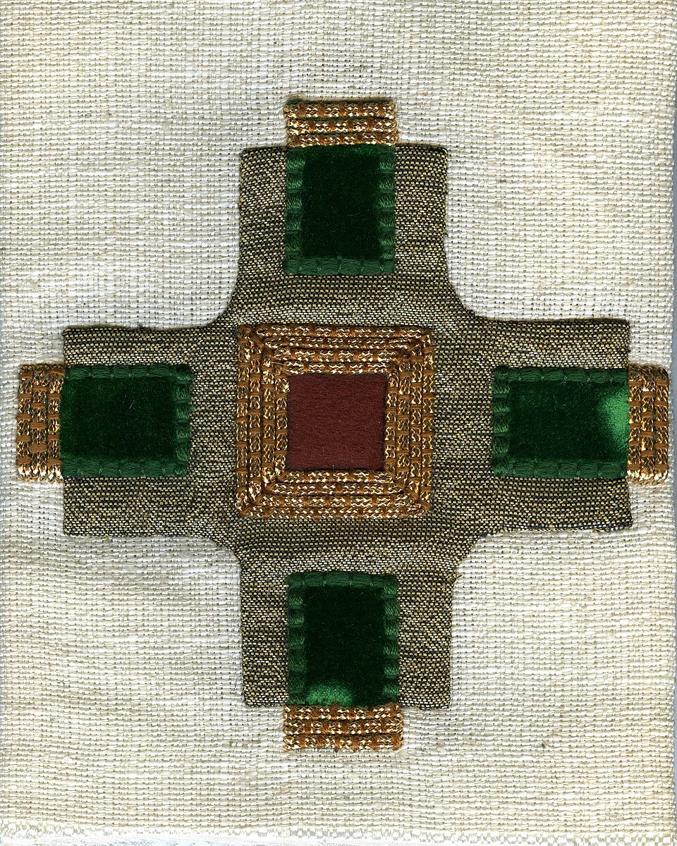 Croix appliquée. Les bords sont recouverts et les points de couture invisibles. Elle est ornée d'un fil d'or décoratif.