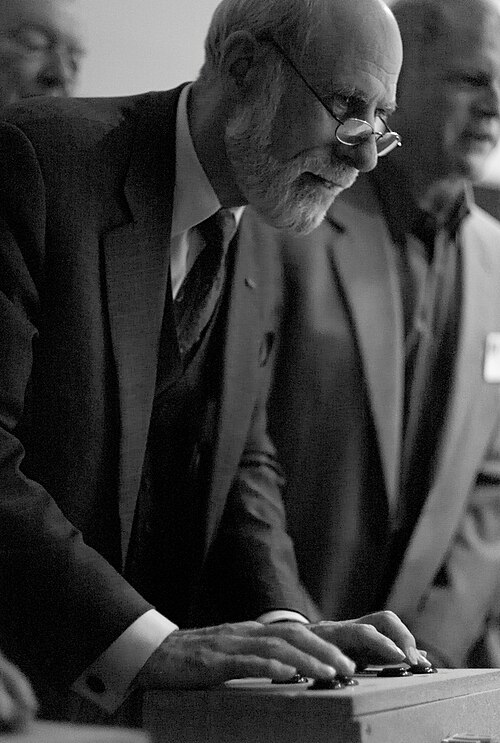 Vint Cerf penché sur une manette sur une table