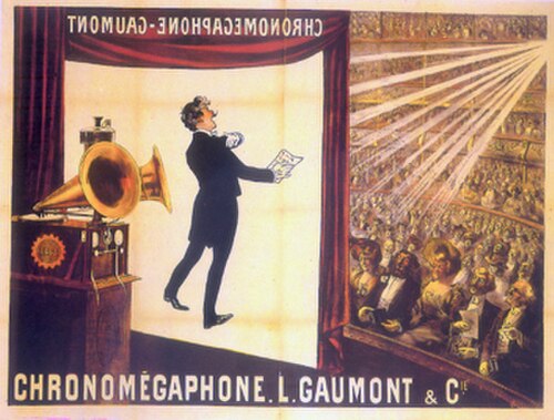 Illustration d'un théâtre vu de l'arrière de la scène. À l'avant de la scène, un écran est suspendu. Au premier plan, un gramophone à deux pavillons. À l'arrière-plan, un large public est assis au niveau de l'orchestre et sur plusieurs balcons. Les mots « Chronomégaphone » et « Gaumont » apparaissent à la fois en bas de l'illustration et, en sens inverse, en haut de l'écran de projection.