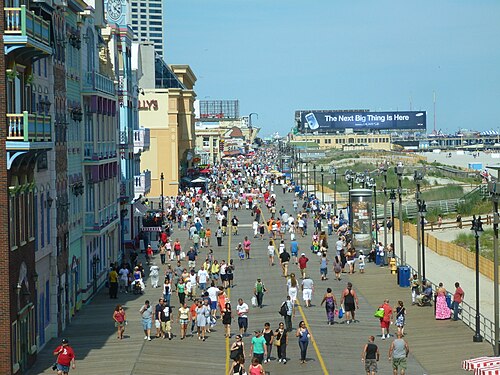 De nombreuses personnes se promènent sur une promenade sur la plage d'Atlantic City, dans le New Jersey