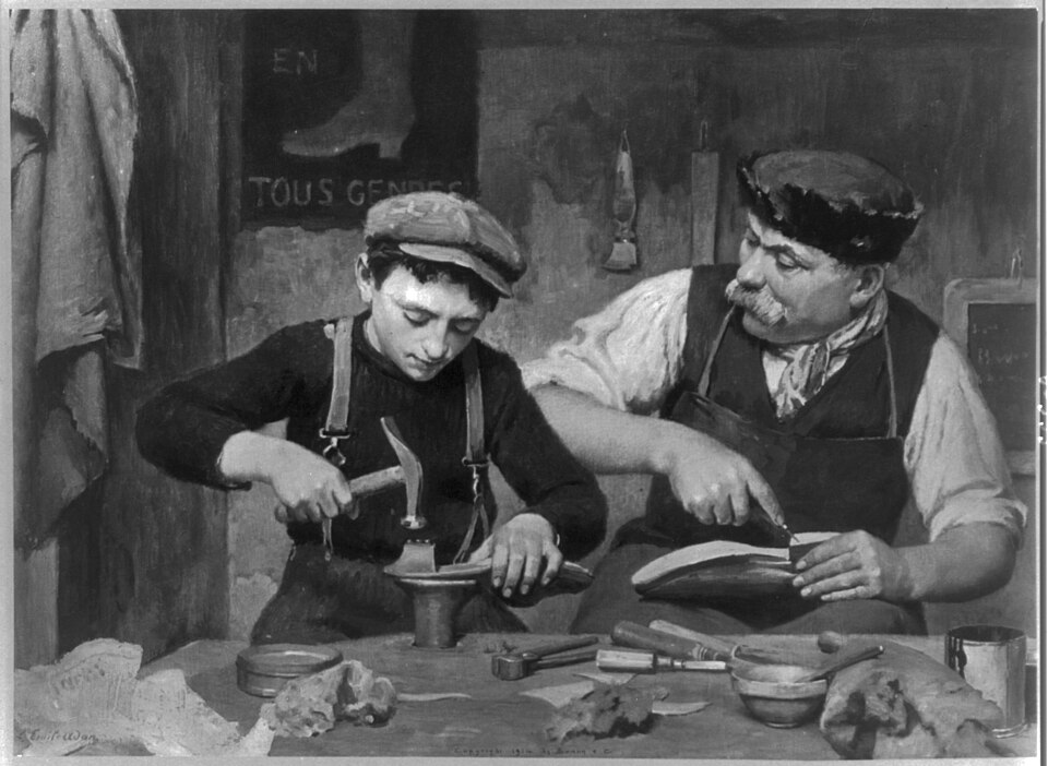Une photo d'un homme et d'un garçon fabriquant des chaussures ensemble.