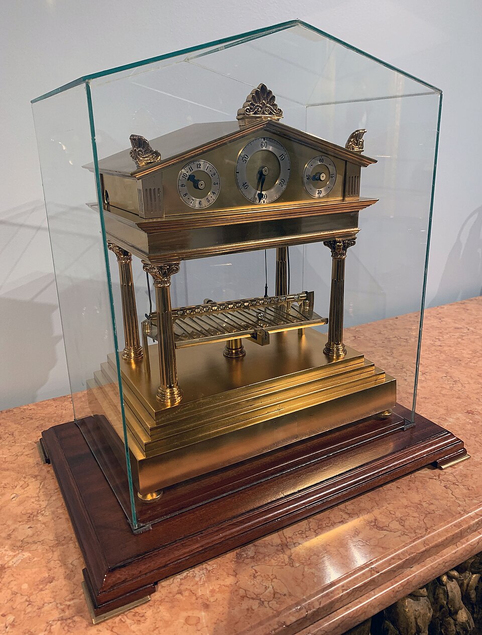 Horloge à mouvement en bronze dans un boîtier en verre