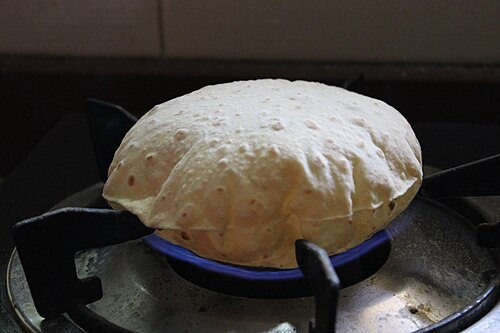 Les chapatis sont cuits sur une flamme nue une fois partiellement cuits sur le tava, ce qui les rend plus moelleux.
