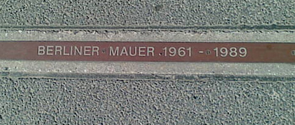 Une plaque « BERLINER MAUER 1961–1989 » près de Checkpoint Charlie indique l'emplacement du Mur.
