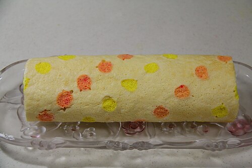 Gâteau roulé avec des points orange et jaunes sur la surface
