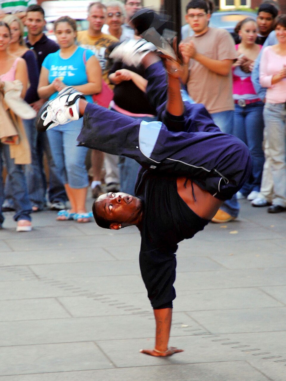 Danse de rue – un danseur de breakdance réalise une figure en équilibre sur les mains.