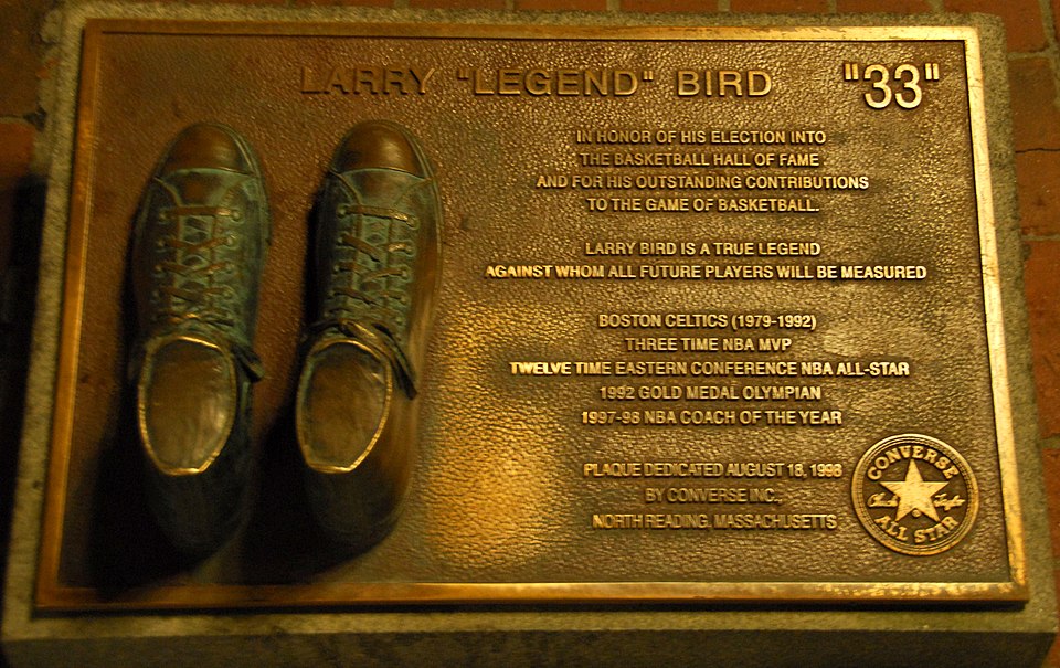 Chaussures en bronze sur une plaque avec un texte décrivant les exploits de Bird en basket-ball