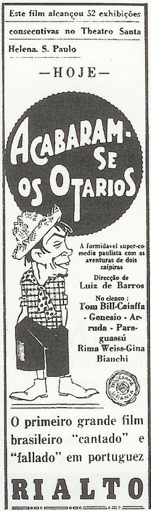 Affiche de film avec illustration d'un homme à la barbiche portant un chapeau de paille, une chemise à carreaux, une courte cravate à pois, un pantalon court et des bottes. Le texte d'accompagnement est en portugais.
