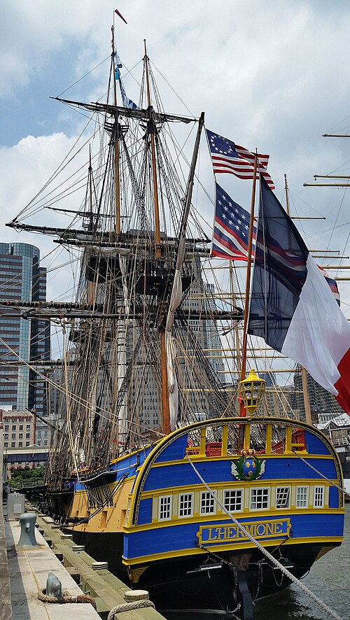 La frégate Hermione amarrée à New York en 2015, battant pavillon Betsy Ross et pavillon Serapis, deux anciens drapeaux et enseignes américains.
