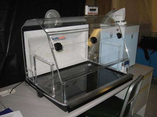 Une boîte en plastique transparente sur un bureau avec des tubes transparents sortant de son sommet