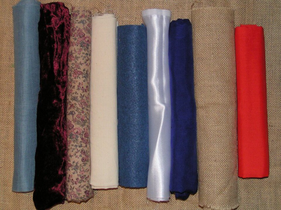 Un assortiment de tissus contemporains. De gauche à droite : coton à tissage régulier, velours, coton imprimé, calicot, feutre, satin, soie, toile de jute, polycoton.