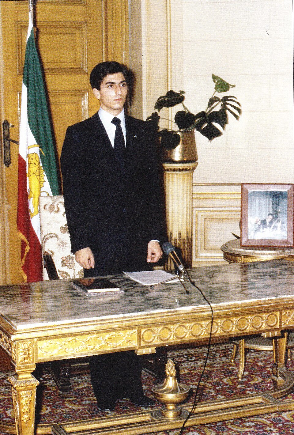 Reza Pahlavi, prince héritier d'Iran, prête serment devant le drapeau iranien.