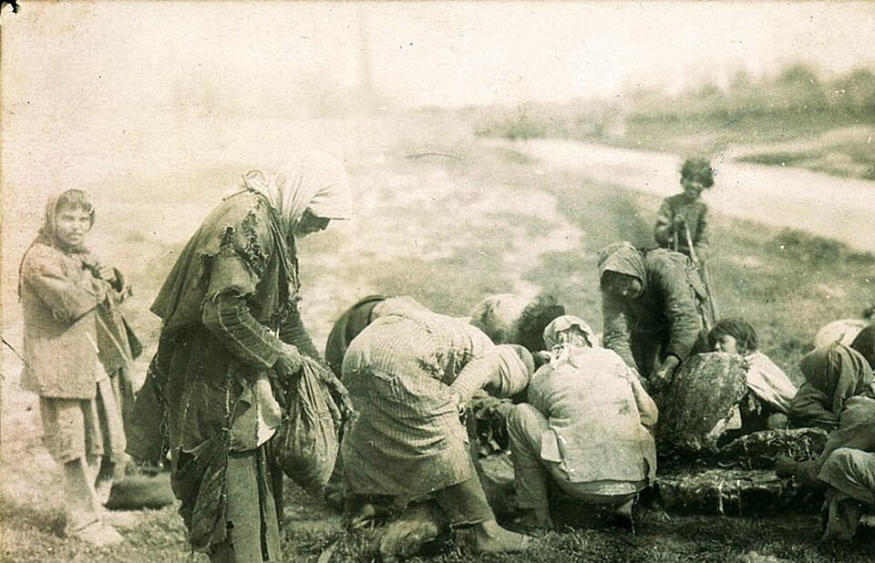Des réfugiés arméniens se rassemblent près du corps d'un cheval mort à Deir ez-Zor, pendant le génocide arménien.