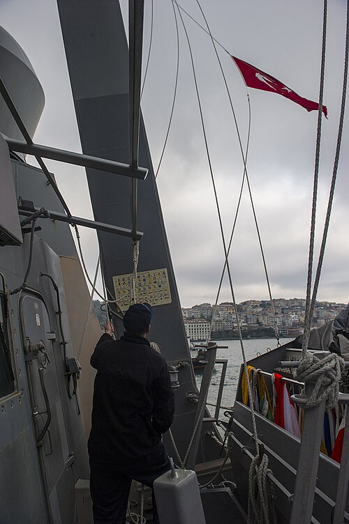 Un drapeau turc de courtoisie est hissé à bord du destroyer USS Truxtun alors que le navire traverse le détroit du Bosphore