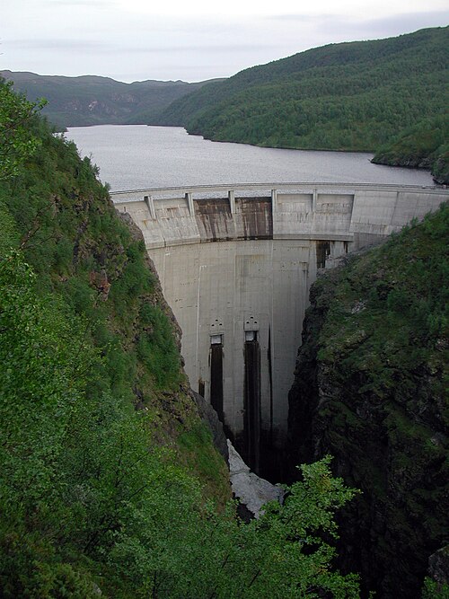 Un barrage blanc, construit entre deux étendues de végétation