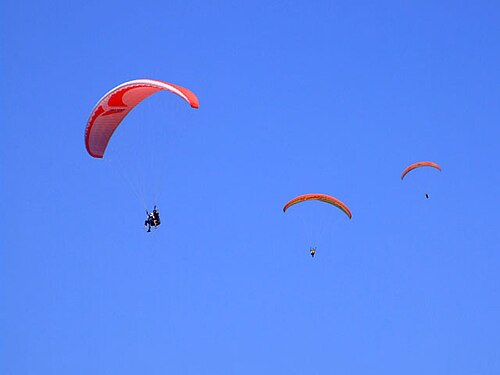 Plusieurs cerfs-volants en vol libre ; les cerfs-volants de parapente peuvent rester en vol dans les courants ascendants thermiques et de pente pendant des heures.